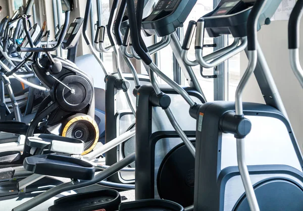 Um número de máquinas de exercício cardio - elipsoides em um centro de fitness — Fotografia de Stock