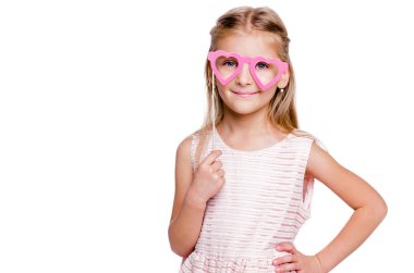 Pembe elbiseli güzel bir kız ve kalp şeklinde kartondan yapılmış gözlükler.
