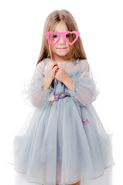Hermosa chica en un vestido gris y gafas de cartón en forma de corazones — Foto de Stock