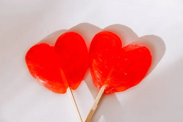 2 солодкі червоні цукерки у формі серця лежать на білому тлі . — стокове фото
