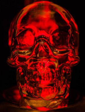 Siyah arka planda kırmızı ışıkla taçlandırılmış cam kafatası