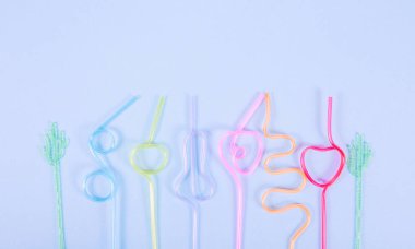  Kokteyller için çok renkli tüpler mor arka planda yer alır. Farklı şekillerde bükülmüş içecekler için çok renkli pipetler. Tatil günü. Metin için yer