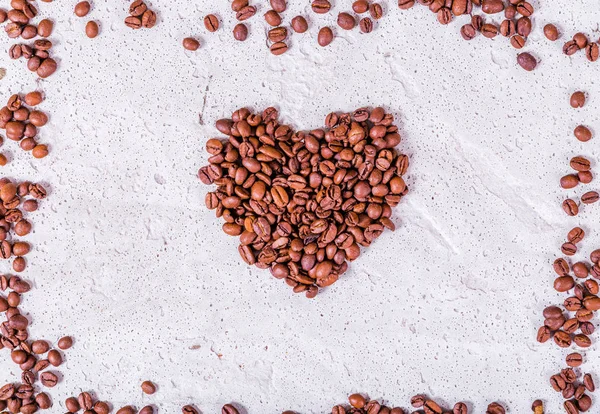 Serce wykonane z ziaren kawy na konkretnym tle. — Zdjęcie stockowe