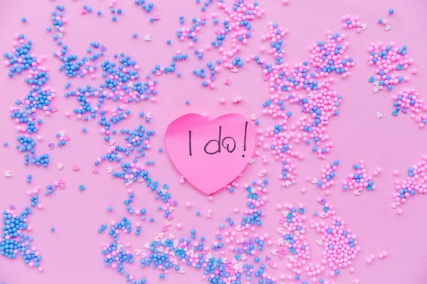 在蓝色和粉色装饰球的背景上的纸粉色心脏。 有一个文字在我的心脏做 — 图库照片