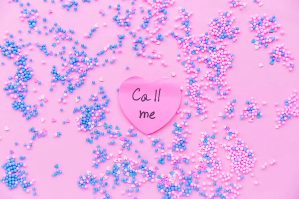 Paper pink heart on a background of decorative balls in blue and pink. There is a text on  heart call me — 스톡 사진