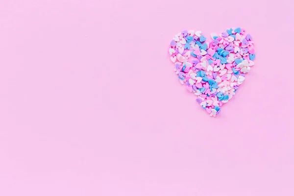 Velké srdce se skládá z mnoha malých srdcí na růžovém pozadí s kopírovacím prostorem pro text nebo gratulace. Láska nebo dovolená . — Stock fotografie