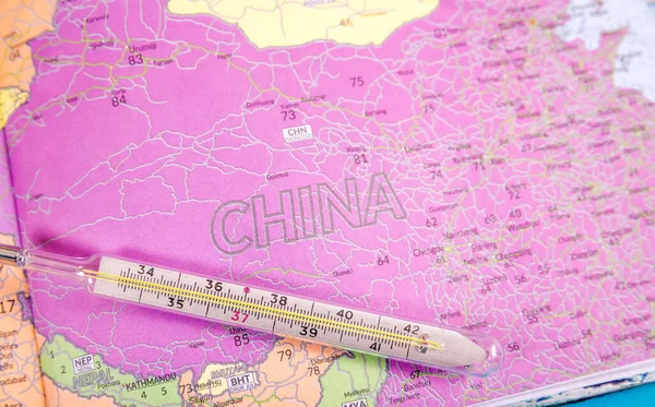 China on the world map. The thermometer lies on the territory of China as a symbol of the outbreak of a new type of coronavirus