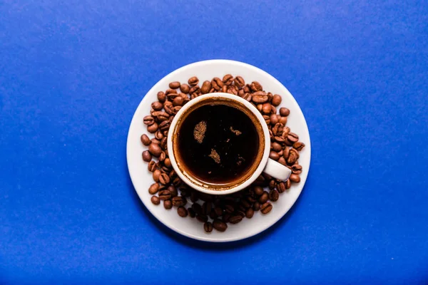 Filiżanka Kawy Spodek Ziarnem Kawy Łyżka Niebieskim Tle Widok Góry — Zdjęcie stockowe