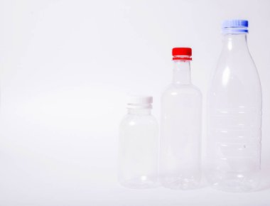 Beyaz arka planda üç boş plastik şişe. Boşluğu kopyala