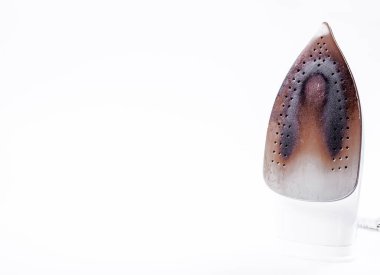 Beyaz arka planda kirli ve yanmış bir yüzeyi olan demir. Yatay fotoğraf