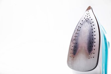 Beyaz arka planda kirli ve yanmış bir yüzeyi olan demir. Yatay fotoğraf