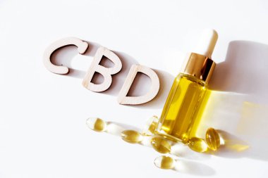 Kapsüllü çeşitli tıbbi esrar ürünleri ve beyaz arka planda izole edilmiş Cbd yağı. Cbd diye bir kelime var. Üst görünüm