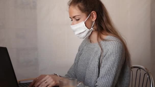 Ένα Κορίτσι Λευκή Προστατευτική Μάσκα Κάθεται Ένα Τραπέζι Δουλεύει Ένα — Αρχείο Βίντεο