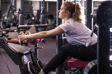 Formda kız karanlık spor salonunda egzersiz yapıyor. Yatay fotoğraf