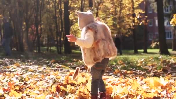 Flicka Går Längs Löven Höstparken Och Cirklar Runt Sig Själv — Stockvideo