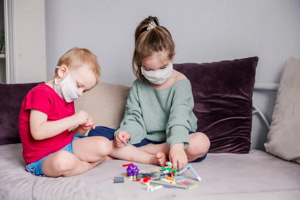 Dos Niños Recogen Constructor Máscaras Médicas Blancas Sentado Sofá Ocio — Foto de Stock