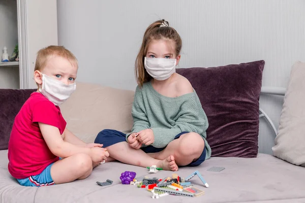 Dos Niños Recogen Constructor Máscaras Médicas Blancas Sentado Sofá Ocio — Foto de Stock