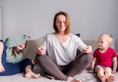 Anne kanepeye oturur, nilüfer çiçeği pozisyonu alır. Çocuklar çığlık atar. Odaklanmış, sakin anne meditasyon yaparken oyuncu çocuğu görmezden gelir. Stressiz kavramlar