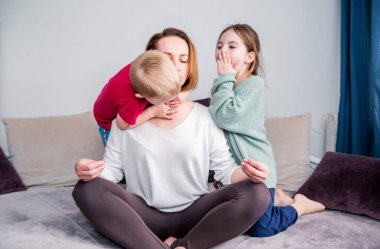 Anne kanepeye oturur, nilüfer çiçeği pozisyonu alır. Çocuklar çığlık atar. Odaklanmış, sakin anne meditasyon yaparken oyuncu çocuğu görmezden gelir. Stressiz kavramlar