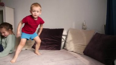 Bir erkek ve bir kız evlerinde kanepede oynaşıyorlar, oynuyorlar. Karantina ve kendini izole etme kavramı. Video