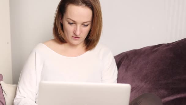 Jovem Caucasiana Sentada Sofá Trabalhando Laptop Menina Bonita Usando Notebook — Vídeo de Stock