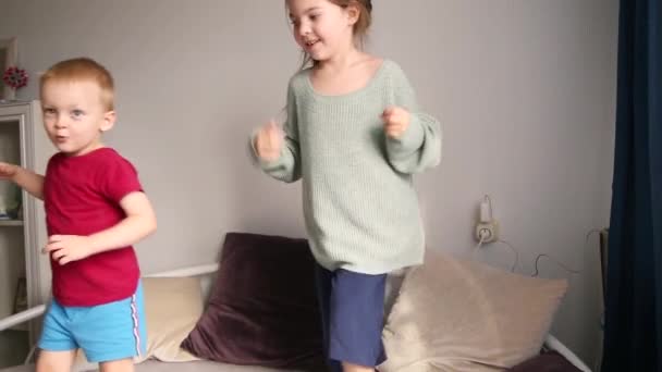 一个男孩和一个女孩在家里的沙发上玩耍 隔离和自我隔离的概念 — 图库视频影像