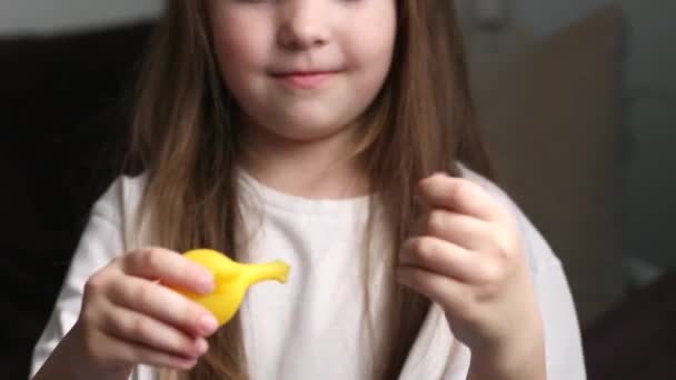 Klein Meisje Een Wit Shirt Speelt Met Een Rubberen Kip — Stockvideo
