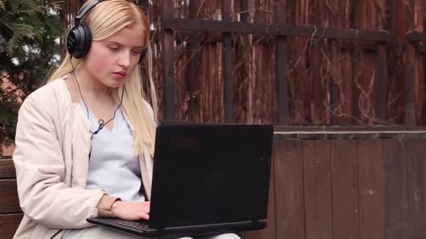 Adolescente Seria Usando Laptop Auriculares Sentados Afuera Vídeo — Vídeos de Stock