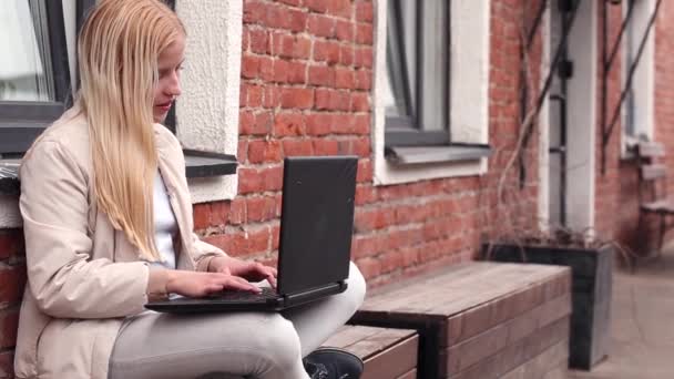 Een Jong Meisje Zit Straat Een Bankje Met Een Laptop — Stockvideo