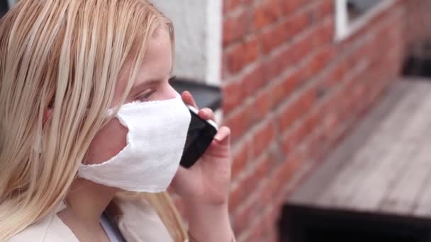 Serieus Meisje Met Een Wit Beschermend Masker Haar Gezicht Pratend — Stockvideo