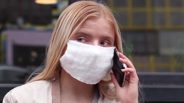 Menina Séria Com Uma Máscara Protetora Branca Rosto Falando Telefone — Vídeo de Stock