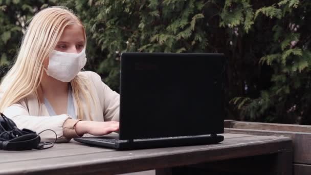 Uma Jovem Senta Uma Rua Café Com Uma Máscara Protetora — Vídeo de Stock