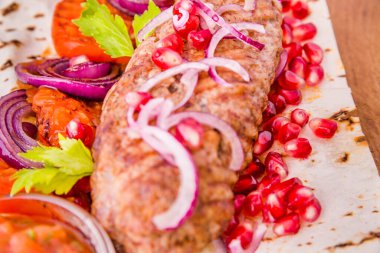 Kebap, şişte et, pide ekmeği, yanında soğan ve domates, tahtadan yapılmış nar tohumu ve sos. Yatay fotoğraf
