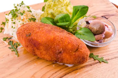 Kızarmış pirzola, patates püresi, lahana turşusu ve tahta tahta üzerinde turşu. Yatay fotoğraf