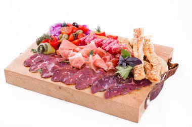 Beyaz arka planda ahşap bir tahtanın üzerinde çeşitli etler..