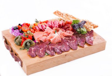 Beyaz arka planda ahşap bir tahtanın üzerinde çeşitli etler..