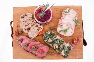Ahşap bir tabakta, sığır rostosu, salamura edilmiş dil, tavuklu terrine, ördek galantin, kiraz sosu. yatay resim
