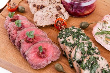 Ahşap bir tabakta, sığır rostosu, salamura edilmiş dil, tavuklu terrine, ördek galantin, kiraz sosu. yatay resim