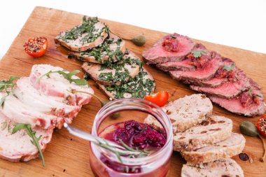 Ahşap bir tabakta, sığır rostosu, salamura edilmiş dil, tavuklu terrine, ördek galantin, kiraz sosu. yatay resim