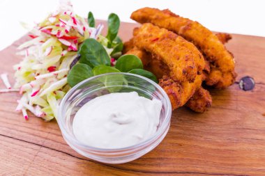 Beyaz bir tabakta ahşap bir tahtada mavi peynir soslu tempura unlu tavuk fileto fırçası. Yatay fotoğraf