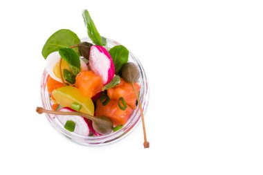 Kırmızı balıklı salata, taze sebzeler, salatalık ve turp, kapari, yumurta, bitkiler, cam kavanozda zeytin. Nesne beyaz bir arkaplanda izole edilmiştir. Yatay fotoğraf