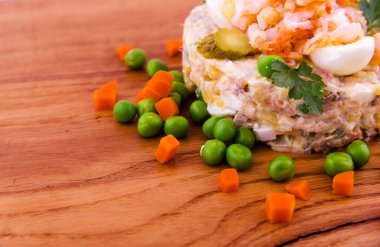 Karidesli Olivier salatası, salatalık turşusu, yumurta, kaynamış havuç ve bezelye dekoru ahşap tepside, yemek, tabak, arka plan. Yatay fotoğraf