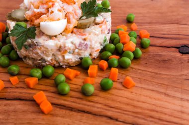 Karidesli Olivier salatası, salatalık turşusu, yumurta, kaynamış havuç ve bezelye dekoru ahşap tepside, yemek, tabak, arka plan. Yatay fotoğraf