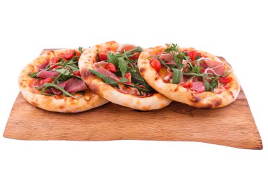Jambonlu üç pizza, domates, ahşap tepside roka. Nesne beyaz bir arkaplanda izole edilmiştir. Yatay fotoğraf