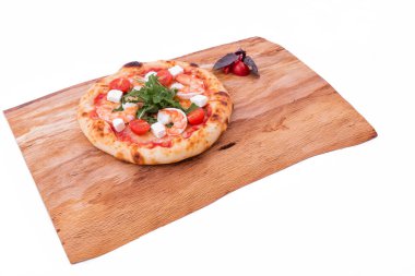Tahta tepside karidesli, domatesli, roka ve peynirli pizza. Nesne beyaz bir arkaplanda izole edilmiştir. Yatay fotoğraf