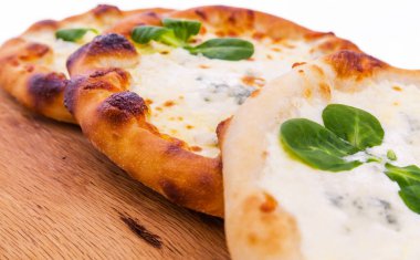 Ahşap arka planda kremalı üç lezzetli taze pizza. Yatay fotoğraf