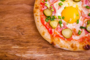 Jambonlu pizza, yumurta, ahşap arka planda salatalık turşusu. Yatay fotoğraf