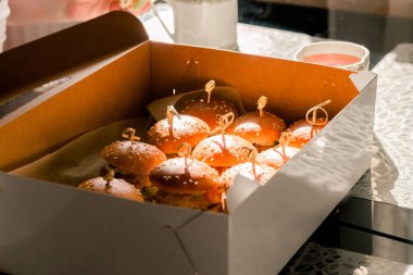 Masada bir kutu mini burger var. Eve teslim. Yatay fotoğraf