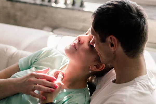 Genç ve güzel beyaz çift evde dinleniyor, mutlu erkek ve kadın yatakta uzanıyor ve sarılıyorlar, uyumlu ilişkiler. Yatay fotoğraf — Stok fotoğraf
