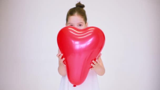 Una Ragazza Vestita Bianco Con Palloncino Forma Cuore Guarda Macchina — Video Stock